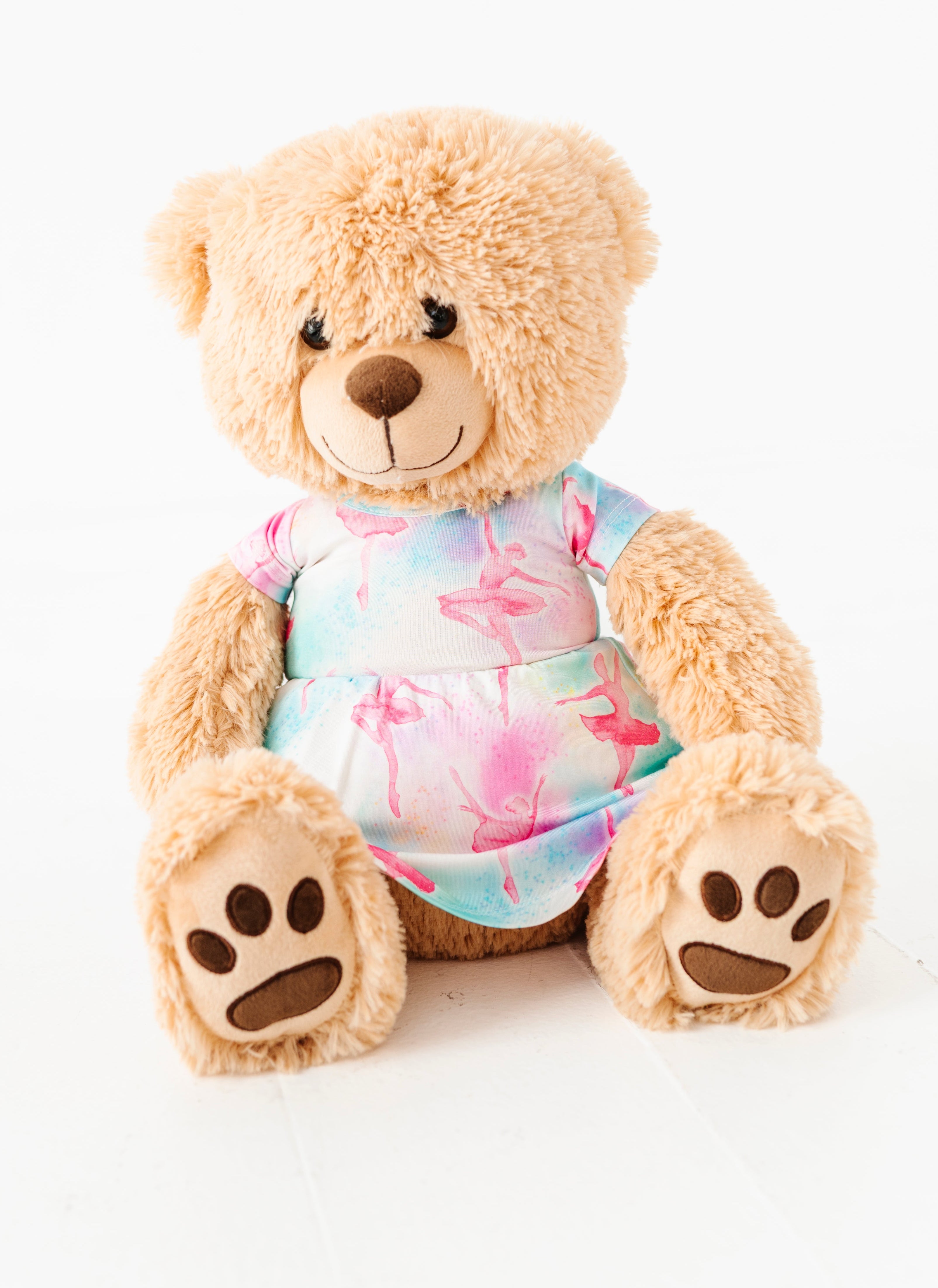 Teddy bear wearing a colorful bamboo dress on a white background